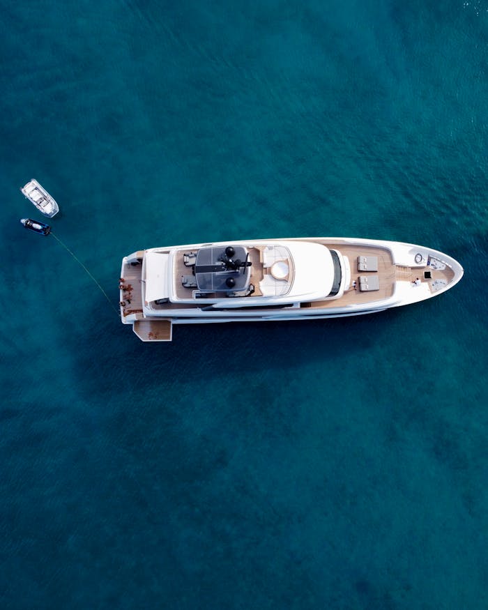Home A stunning aerial view of a luxury yacht on the clear waters of Paros, Greece.