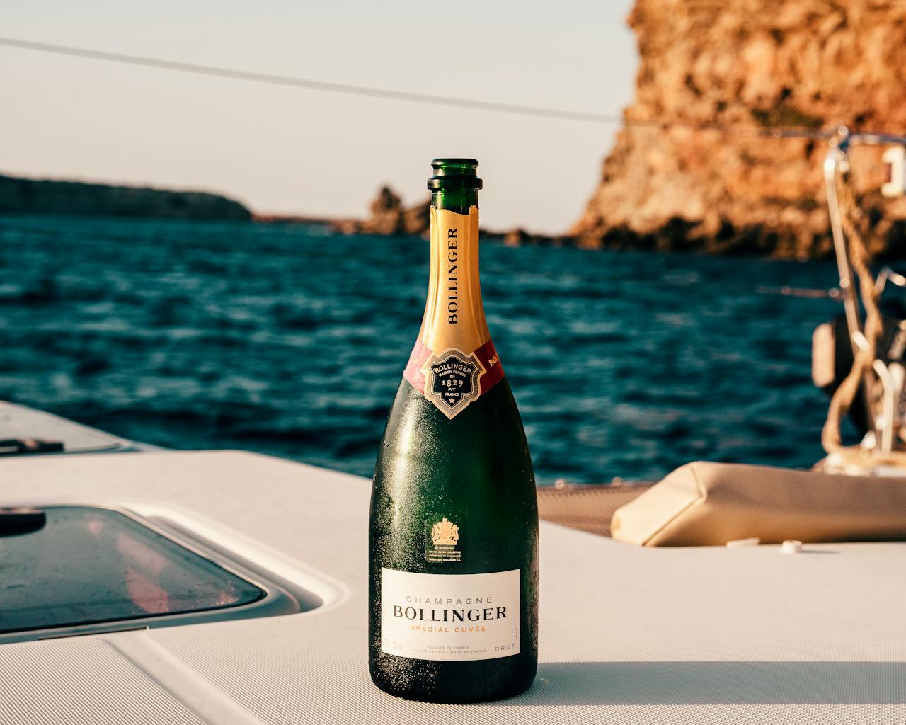 Home Bollinger champagne bottle on a yacht with Ibiza's ocean view, perfect for celebrations.